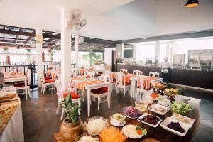 a restaurant with plates of food on a table at Kata Silver Sand in Kata Beach