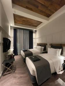 a hotel room with two beds and a flat screen tv at Junibino Hotel Hongdae in Seoul