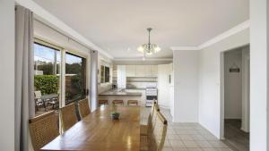 a kitchen and dining room with a wooden table in a room at Vietta Rene Umina Beach in Umina