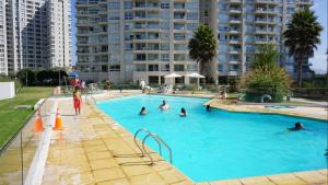 um grupo de pessoas a nadar numa piscina em Departamento Marina Horizonte II em Coquimbo