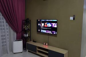 TV de pantalla plana en la pared de la sala de estar. en CASA Singgah Homestay en Chemor
