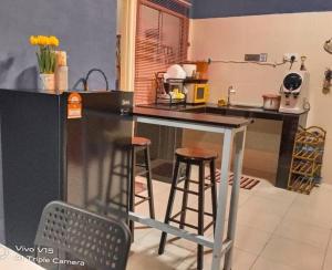 uma cozinha com dois bancos de bar e um balcão em CASA Singgah Homestay em Chemor