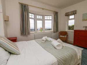 a bedroom with a large white bed with two pillows at Trelawns in Mawgan Porth