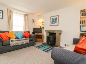 a living room with two couches and a fireplace at Calac Cottage in Mousehole