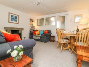 ein Wohnzimmer mit einem Sofa und einem Tisch in der Unterkunft Calac Cottage in Mousehole