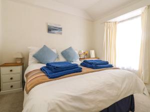 ein Schlafzimmer mit einem Bett mit blauen Handtüchern darauf in der Unterkunft Calac Cottage in Mousehole