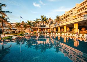 een zwembad in een resort met stoelen en palmbomen bij The Moon Beach Museum Resort in Onna