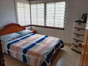 a bedroom with a bed and a window and a dresser at Casa de campo San Fernando in Villeta