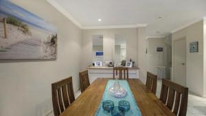 a dining room with a wooden table and chairs at Ocean Beach Holiday House in Ettalong Beach
