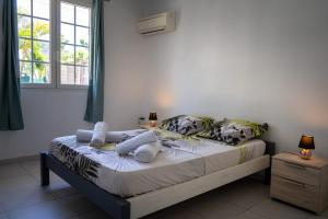 um quarto com uma cama e uma janela em La Villa Noémie - Parking - Proche des Plages em Sainte-Anne
