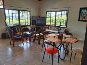 a living room with tables and chairs and a tv at Casa de campo San Fernando in Villeta