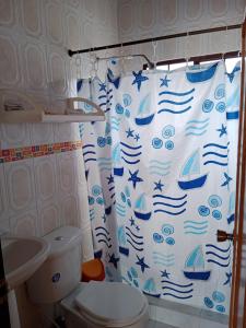 y baño con cortina de ducha y aseo. en Casa de campo San Fernando, en Villeta