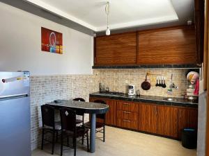 a kitchen with a table and a refrigerator at Appartement / Logement Imsouane. in Imsouane