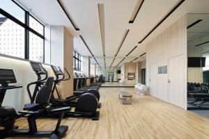 a gym with a row of treadmills and ellipticals at Courtyard by Marriott Nagoya in Nagoya