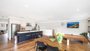 a kitchen and living room with a table and chairs at Bay Edge - Tascott in Point Clare