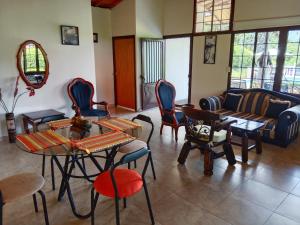 uma sala de estar com cadeiras e mesas e um sofá em Casa de campo San Fernando em Villeta