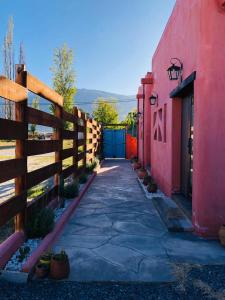 a sidewalk next to a red building with a fence at WAYTAY in Cafayate
