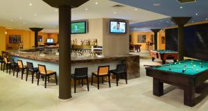 eine Bar mit Billardtischen und eine Bar mit Rechnungen in der Unterkunft Catalonia Yucatan Beach - All Inclusive in Puerto Aventuras