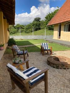 a patio with two chairs and a fire pit at Sitio Sao Francisco de Assis in Santo Antônio do Pinhal