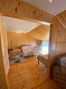 a large room with two beds in a room with wooden walls at Sunny Beach Hotel in Cholpon-Ata +32 photos