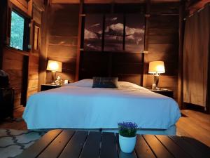 a bedroom with a bed and two lamps on a table at Chéel lodge & Camping in Puerto Morelos