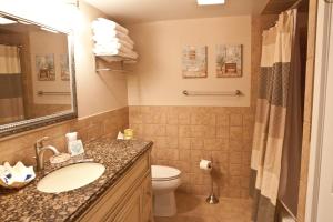 a bathroom with a sink and a toilet and a mirror at Watson's Regency Suites in Ocean City