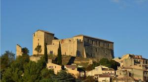 un château au sommet d'une colline avec des maisons dans l'établissement Maisonnette studio jardinet, à Gréoux-les-Bains