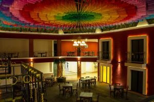 een grote kamer met tafels en een kleurrijk plafond bij Hotel Casa Real Cholula in Cholula