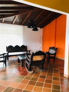 a living room with benches and orange walls at Espectacular casa de campo en finca cafetera in Moniquirá