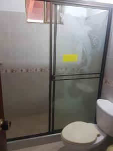 a bathroom with a glass shower with a toilet at Espectacular casa de campo en finca cafetera in Moniquirá