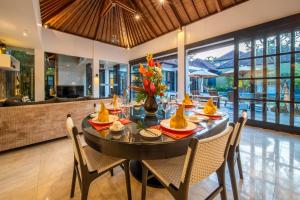 uma sala de jantar com mesa e cadeiras numa casa em Lotus Luxury Villa Seminyak em Seminyak