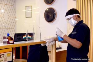 un hombre en una habitación con una máscara y guantes en Hotel Mandakini Palace, en Nueva Delhi