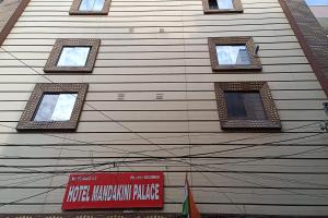 un edificio con cuatro ventanas y una señal en él en Hotel Mandakini Palace, en Nueva Delhi