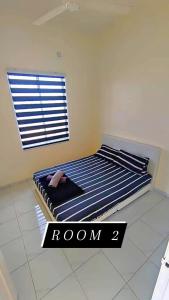 ein Schlafzimmer mit einem Bett mit einem Zimmerschild in der Unterkunft Az HOMESTAY PENDANG KEDAH in Pendang