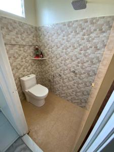 a bathroom with a toilet and a tile wall at Az HOMESTAY PENDANG KEDAH in Pendang