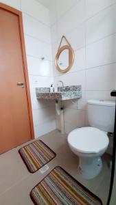 a bathroom with a toilet and a sink and a mirror at Apto novo Parque Mosaico in Manaus