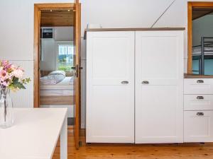 einen weißen Schrank in einem Zimmer mit einem Bett in der Unterkunft Holiday home Broager in Broager