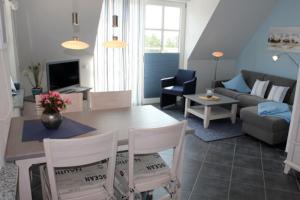 sala de estar con mesa y sofá en Residenz am Hafen Neptunsuite, en Ahrenshoop
