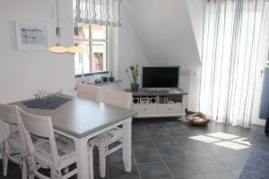 sala de estar con mesa y TV en Residenz am Hafen Neptunsuite, en Ahrenshoop