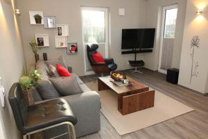 a living room with a couch and a tv at Aquamarin Ostseetraumsuite 10 in Neuhaus