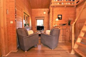 een kamer met 2 stoelen, een bureau en een televisie bij Ferienhäuser Ferienhaus, Haus Auszeit in Neuhaus