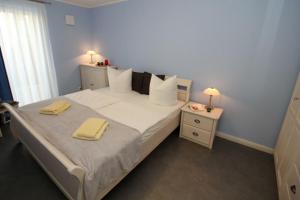 1 dormitorio con 1 cama con 2 toallas amarillas en Aquamarin Ostseetraumsuite 01, en Neuhaus