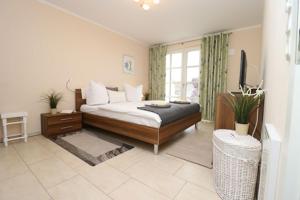 a bedroom with a bed and a large window at Residenz am Hafen Boddensuite in Ahrenshoop