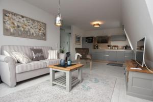 uma sala de estar com um sofá e uma mesa em Aquamarin Ostseetraumsuite 12 em Neuhaus