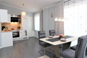 cocina y comedor con mesa y sillas en Meerquartier App 08, en Neuhaus