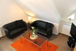 - un salon avec deux canapés noirs et une table dans l'établissement Strandhaus Strandhaus, App 01, à Dierhagen