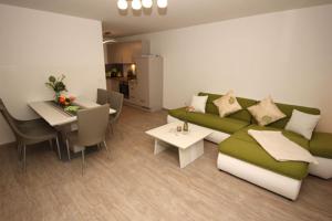a living room with a green couch and a table at Aquamarin Ostseetraumsuite 02 in Neuhaus