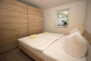 a bedroom with a bed with white sheets and a window at Aquamarin Ostseetraumsuite 02 in Neuhaus