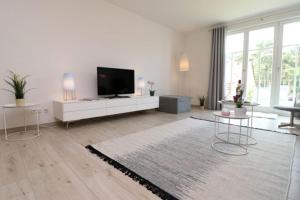 uma ampla sala de estar com uma televisão de ecrã plano em Bickbeeren Schweiz Villa Catrina, App 05 em Dierhagen