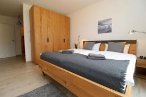 1 dormitorio con 1 cama grande y cabecero de madera en Bickbeeren Schweiz Villa Catrina, App 05, en Dierhagen